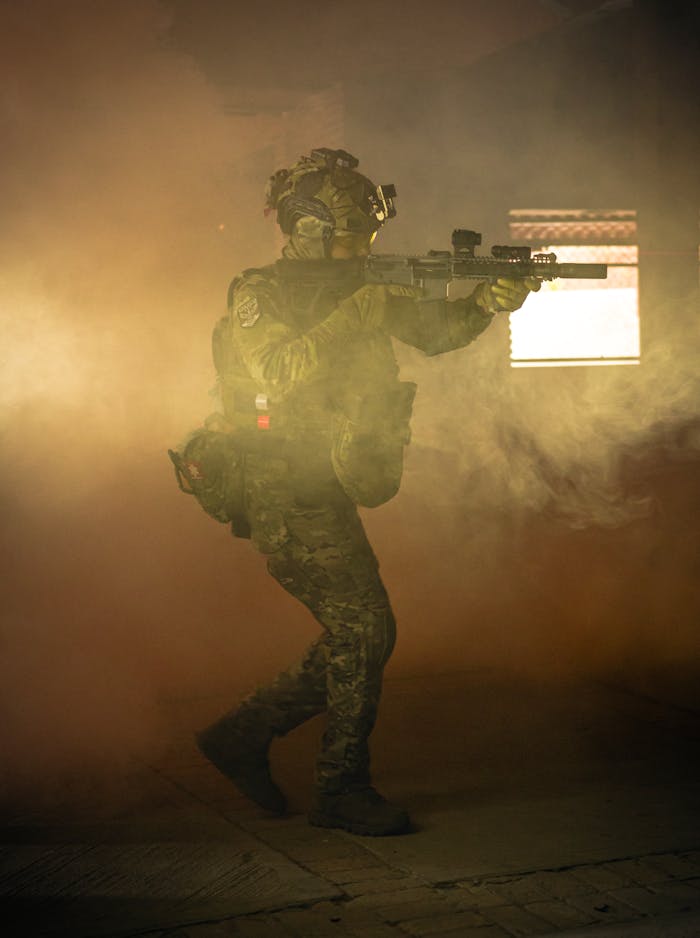Armed soldier navigating a smoke-filled indoor setting, showcasing tactical gear and prowess.
